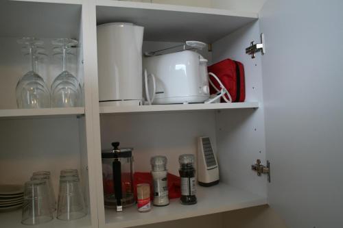 a cupboard filled with lots of dishes and glasses at South Central Apartments in Brautarholt