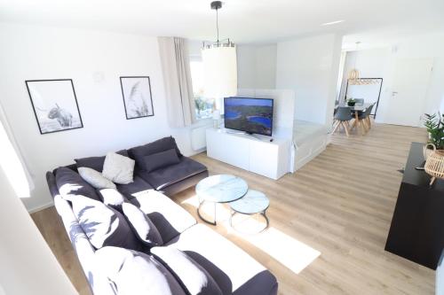 uma sala de estar com um sofá e uma televisão em Meerhaus em Cuxhaven