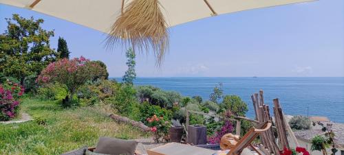 einen Meerblick von einem Haus mit Stühlen in der Unterkunft Villa Magnolia in Santa-Maria-di-Lota