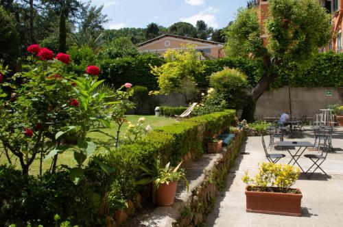 a garden with roses and plants and a table and chairs at Villa Riari Garden in Rome