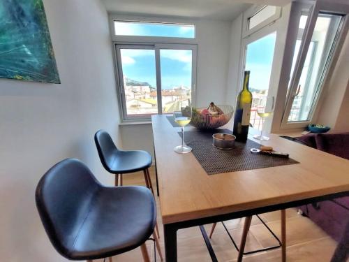 a dining room table with two chairs and wine glasses at Orla Beach Apartment in Makarska