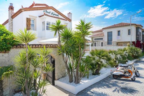 a scooter parked in front of a house with palm trees at Anıt Konak in Alaçatı