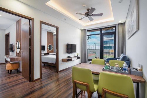 a living room with a dining room table and a bedroom at Chi House Danang Hotel and Apartment in Da Nang