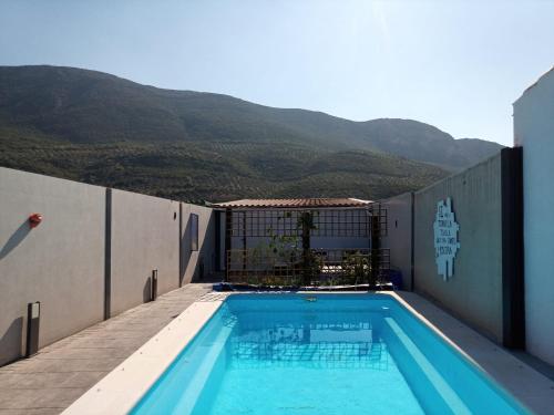 a swimming pool on the side of a building with mountains at Casa Holmes in Las Casillas