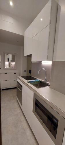 a kitchen with white cabinets and a sink at LittleAndCosy in Turin