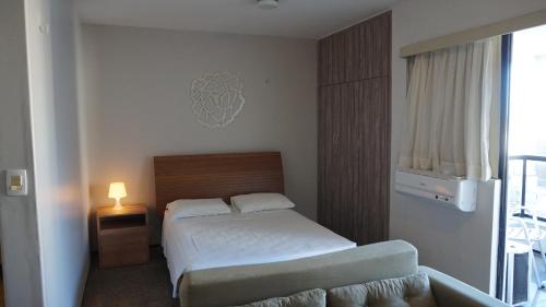 a bedroom with a bed and a couch in it at Via Venetto Flat - no melhor bairro de Fortaleza in Fortaleza