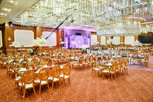 a banquet hall with tables and chairs and chandeliers at Rehana Plaza Hotel in Cairo
