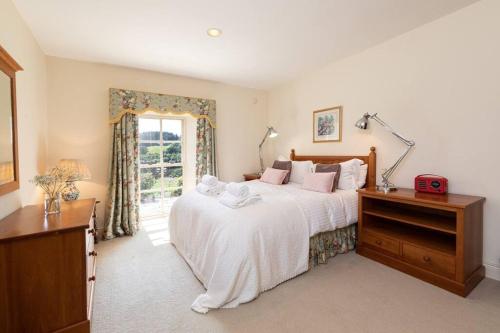 a bedroom with a large bed and a window at Charlton Gate in Greenhaugh
