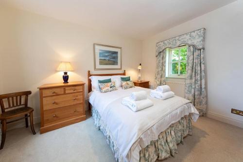 a bedroom with a bed and a dresser and a window at Charlton Gate in Greenhaugh