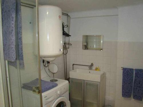 Cosy Appartment في لشبونة: حمام صغير مع غسالة ومغسلة