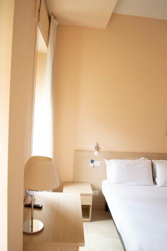 a bedroom with a bed and a table and a lamp at Villa Riari Garden in Rome