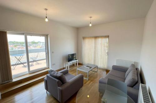 a living room with a couch and a tv at Modern 2 bed flat with balcony in Southend-on-Sea