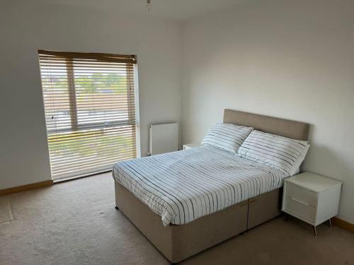 1 dormitorio con cama y ventana grande en Modern 2 bed flat with balcony, en Southend-on-Sea