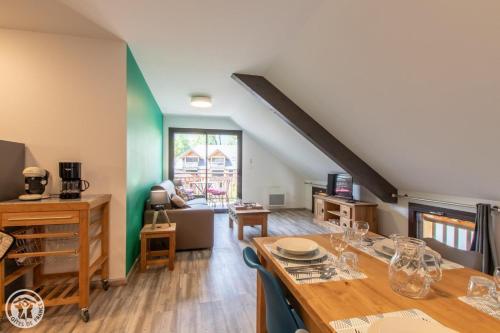 uma sala de jantar com uma mesa e uma sala de estar em Gite Annecy 201- Au Royaume des Castors - Appt 201 em Doussard