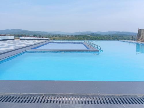 a large swimming pool with blue water at The Arcadia Pool and Villa - Umroi in Shillong