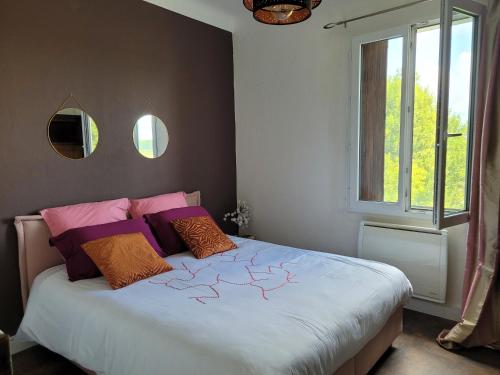a bedroom with a bed with two pillows and a window at MAS TAREAU LE DAMIER in Beaucaire