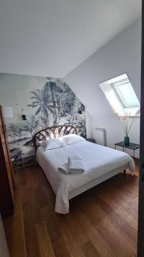 um quarto com uma cama com um quadro na parede em Villa 5*, mer à 3 mn, piscine intérieure à 28° em Gonneville-en-Auge