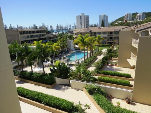 an aerial view of a resort with a swimming pool and palm trees at The Village at Burleigh in Gold Coast