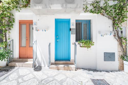 two blue doors on a white house at Vico di Ostuni Apartments by Rentbeat in Ostuni