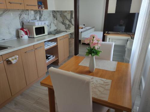 eine Küche mit einem Tisch und einer Blumenvase darauf in der Unterkunft Pension VIDHOUS 1 in Franzensbad