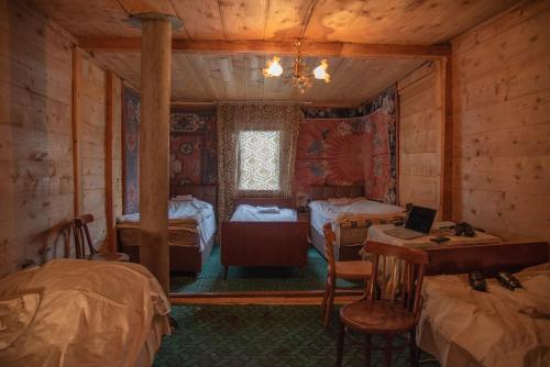 una habitación con 2 camas y un escritorio en una cabaña en Oda, en Khulo