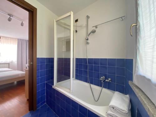 bagno con piastrelle blu, doccia e vasca di Stresa Centro a Stresa