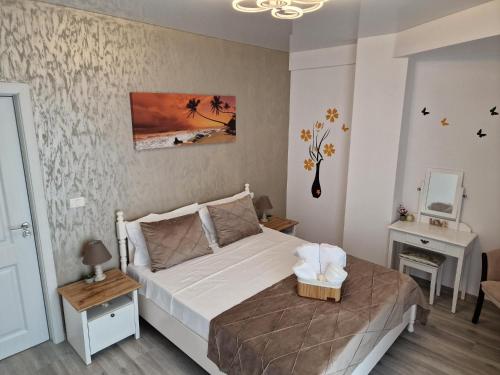 ein Schlafzimmer mit einem großen weißen Bett und einem Tisch in der Unterkunft Crystal Sands Residence in Eforie Nord