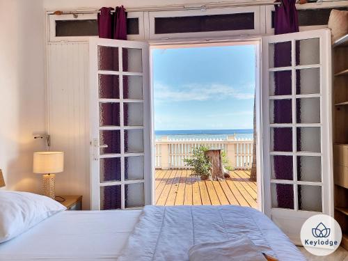 - une chambre avec une porte ouverte offrant une vue sur l'océan dans l'établissement Les Mosalas - 2 et 3 étoiles - pieds dans l'eau - Lagon de Saint-Leu, à Saint-Leu