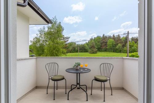 a patio with two chairs and a table on a balcony at Villa Artemis in Plitvička Jezera