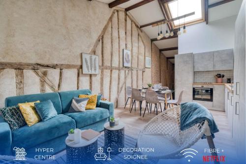 Una sala de estar con un sofá azul y una mesa. en Cosy Up - Vieux Port - Hyper Centre, en La Rochelle