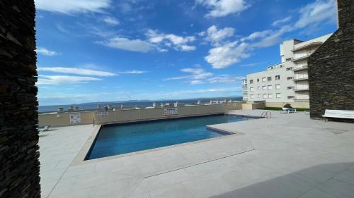 uma piscina no telhado de um edifício em Luminoso apartamento frente al mar con piscina em Roses