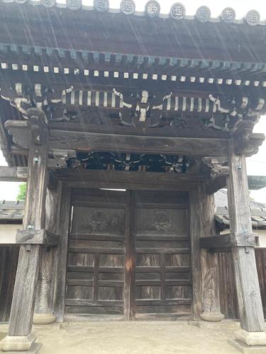 a wooden building with a large wooden door at Guest House Salt Beach in Yokkaichi