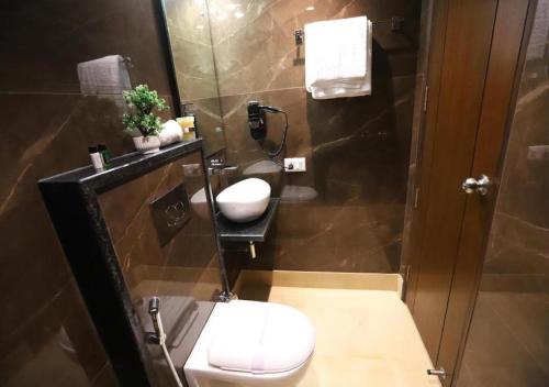 a bathroom with a toilet and a sink at Hotel The Leaf - Gomti Nagar Lucknow in Lucknow