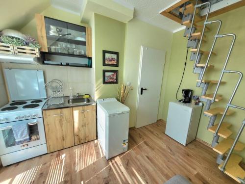 una pequeña cocina con fogones y nevera. en Penthouse Apartments PERLA, Vasiliko, en Tsarevo