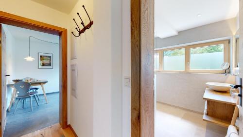 a hallway leading to a kitchen with a table and a window at Fischer`s Postresidenzen Ettal in Ettal