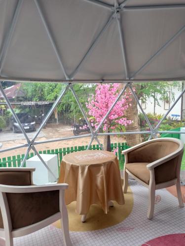 a tent with a table and two chairs and a window at Everest Resort Samui - SHA Plus in Mae Nam