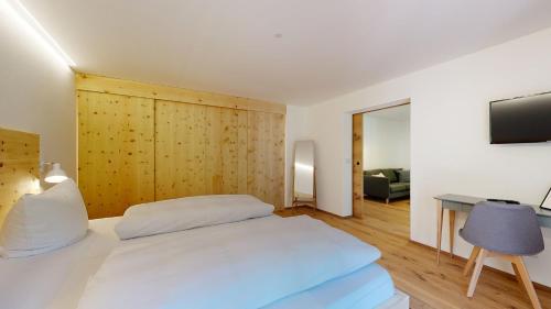 a bedroom with a bed and a desk and a television at Fischer`s Postresidenzen Ettal in Ettal