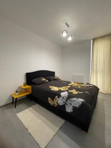 een slaapkamer met een bed met een zwart dekbed bij Apartament Melanie in Oradea