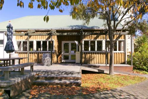 a building with a picnic table and a tree at Turangi Bridge Motel in Turangi