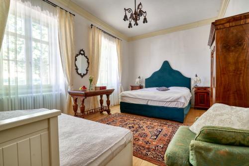 a bedroom with a bed and a chair in a room at VILLABOGArT Esküvő-és Rendezvényhelyszín in Alsobogát