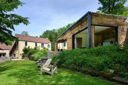 a couple of chairs sitting on the grass in a yard at Demeures et Châteaux Moulin des Templiers Hôtel & SPA in Pontaubert