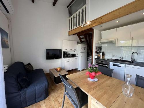 une cuisine et un salon avec une table et un canapé dans l'établissement Studio Cabine Mezzanine, Clim, Parking Privé, Plage et Commerces à 300m - FR-1-702-8, au Cap d'Agde