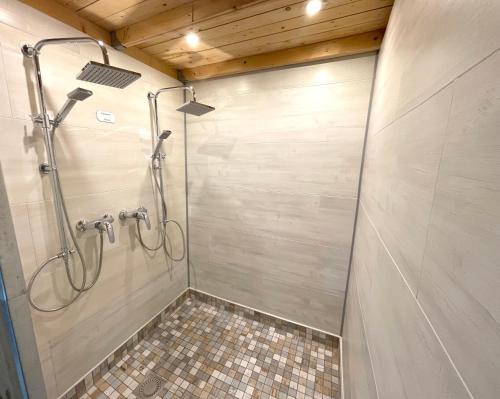 a shower stall in a bathroom with a tile floor at Captain Pahlen Ferienanlage in Zingst