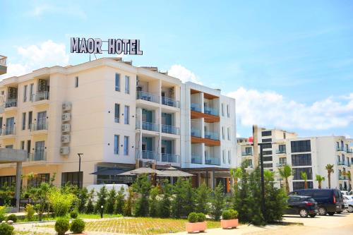 a white building with a sign on top of it at Maor Hotel in Vlorë
