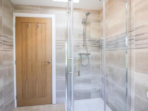 a shower with a glass door in a bathroom at Olive Cottage in York