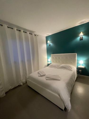 una camera con un letto bianco e una parete blu di Villa Zuria T4 a Bonifacio