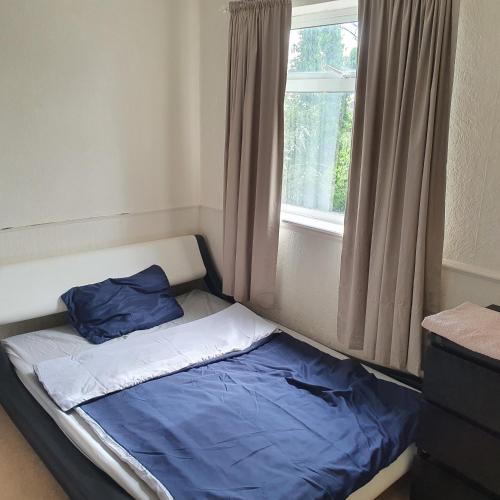 a small bed in a room with a window at Alex's place in Hinckley