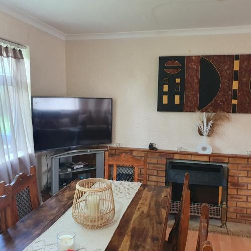 a living room with a table and a flat screen tv at Alex's place in Hinckley