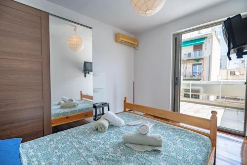 a bedroom with two beds and a large window at Athens city center maisonette for 3 persons by MPS in Athens