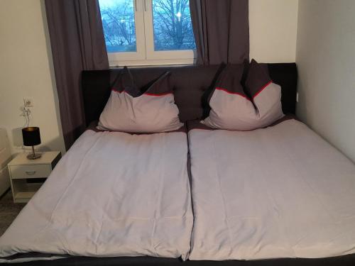 a bed with two pillows on it in a bedroom at Berlin - Schönefeld grüne Wohnung in Schönefeld